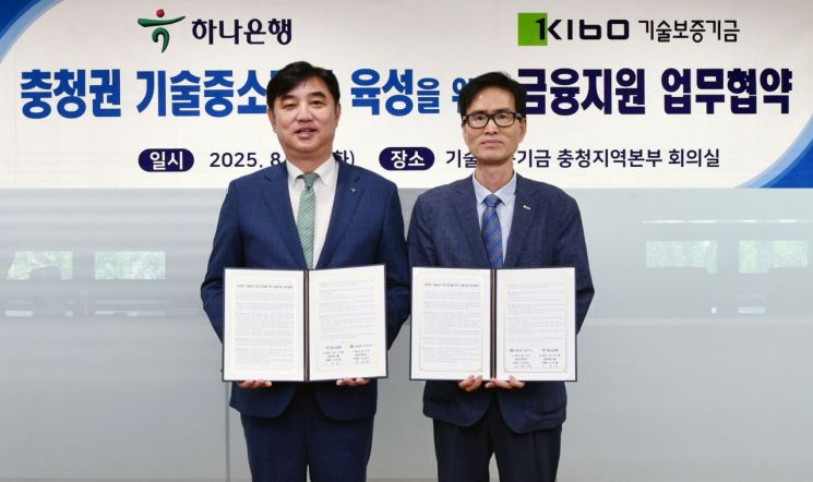 협약식에 참석한 이동열 하나은행 충청영업그룹 부행장(왼쪽)이 정대영 기술보증기금 충청지역본부장과 협약서를 들고 기념촬영을 하고 있다. 하나은행
