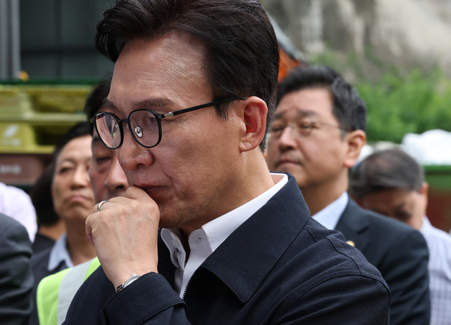 김민석 더불어민주당 대표가 10일 서울 종로구 창신동 적환장에서 환경미화원 작업환경 및 안전을 점검, 생활폐기물 수집 및 운반 업무 현황에 대한 보고를 받고 있다. [연합뉴스]
